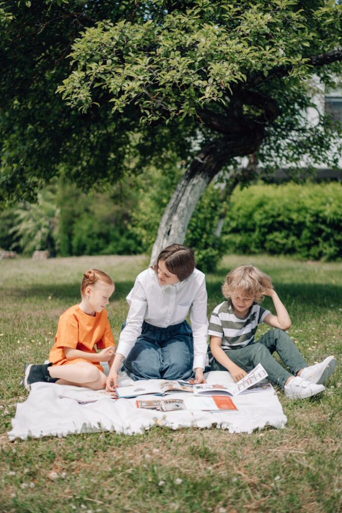 A Woman Teaching Children while on a Blanket Outdoors